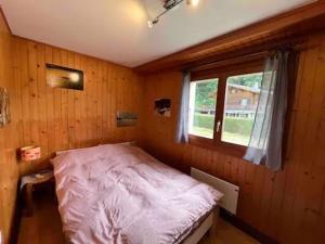 a bedroom with a bed in a room with a window at Appartement Chalet France in Salvan