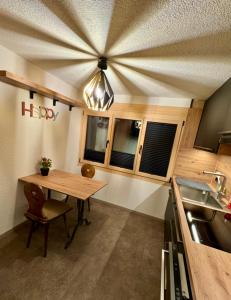 eine Küche mit einem Holztisch und einem Kronleuchter in der Unterkunft Ferienwohnung Brunni-Lodge direkt am Grossen Mythen in Alpthal