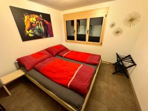ein Schlafzimmer mit einem großen Bett mit roter Bettwäsche in der Unterkunft Ferienwohnung Brunni-Lodge direkt am Grossen Mythen in Alpthal