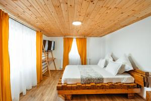 1 dormitorio con 1 cama con techo de madera en Casa Davana, en Cluj-Napoca