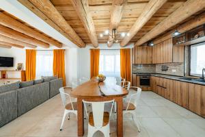 a kitchen and dining room with a wooden ceiling at Casa Davana in Rogojel