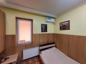 a small bedroom with a bed and a window at Arnautskaya apartments in Odesa