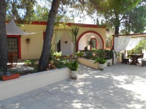 a courtyard of a house with a table and trees at B&B Santa Venardia in Gallipoli