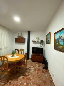 ein Esszimmer mit einem Tisch und einem TV in der Unterkunft El rincón del Corneja in Villafranca de la Sierra