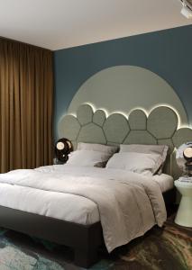 - une chambre avec un grand lit et une grande tête de lit dans l'établissement Mercure Annecy Centre, à Annecy