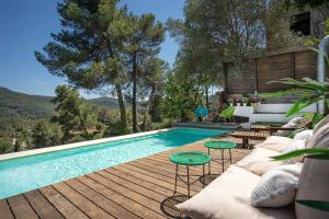a swimming pool on a wooden deck next to a house at THE LOFT - with private pool in Corbera de Llobregat