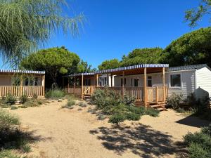 a small house with a porch and a deck at Albatross Mobile Homes on Camping El Pla de Mar in Malgrat de Mar