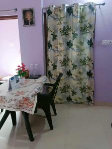 a dining room with a table and a curtain at Michelle Residency in Rourkela