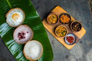 a green plate with different types of food on it at Sama Kosgoda - A Santani Retreat in Kosgoda