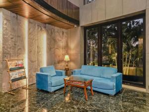 2 sillas azules y una mesa de centro en la sala de estar. en Treebo Trend Niraali Executive en Pune