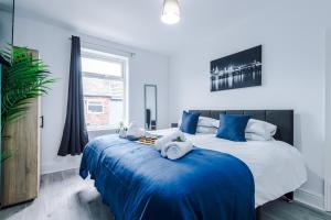 a bedroom with a large bed with blue sheets at Stunning 3-bed home in Anfield by 53 Degrees Property, Ideal For Big Groups, FREE parking! in Liverpool