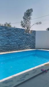une piscine bleue en face d'un mur de briques dans l'établissement Villa B&B, à Sousse