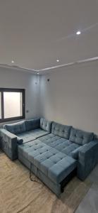 Villa B&B في سوسة: أريكة زرقاء كبيرة موجودة في الغرفة