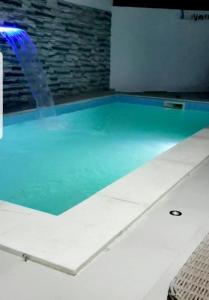 Villa B&B في سوسة: حمام سباحة بمياه زرقاء في الغرفة