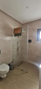 La salle de bains est pourvue d'une douche et de toilettes. dans l'établissement Villa B&B, à Sousse