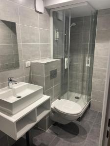 a bathroom with a toilet and a sink and a shower at The Originals City, Hôtel Éclipse, Lyon Est (Inter-Hotel) in Décines-Charpieu