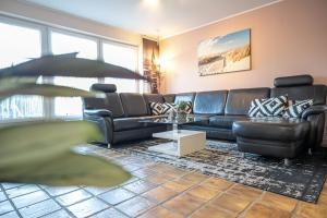 a living room with a couch and a table at Ferienhaus Seeschwalbe, FeWo Vermittlung Nordsee in Dangast