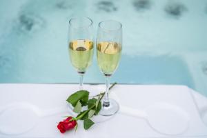 dos copas de champán y una rosa sobre una mesa en Hiša Erlah, en Bohinj