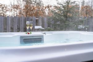 a hot tub with two glasses of champagne at Hiša Erlah in Bohinj