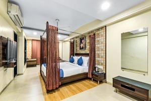 a bedroom with a canopy bed and a flat screen tv at Krushnai Resort in Lonavala