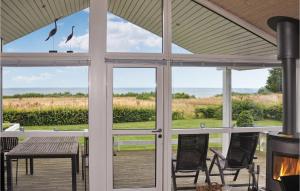 a screened porch with glass doors and a table and chairs at Holiday Home Bellevue Iii in Skovby