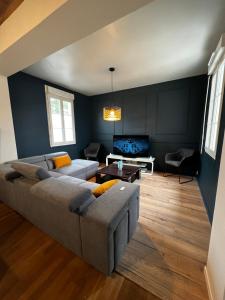 a living room with a couch and a table at Maison chaleureuse avec jardin in Bourges