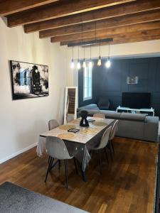 a living room with a table and chairs and a couch at Maison chaleureuse avec jardin in Bourges