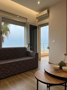 een woonkamer met een bank en een tafel bij SKetch Apartments in Durrës