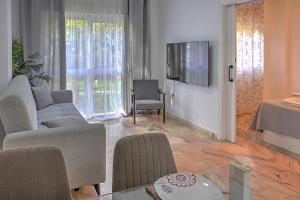 uma sala de estar com um sofá e uma televisão em Precioso piso residencial em Sevilha