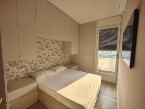 ein kleines Schlafzimmer mit einem Bett und einem Fenster in der Unterkunft Ottoboni 2B Luxury Penthouse in Mailand