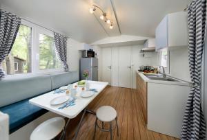 een kleine keuken met een witte tafel en stoelen bij Albatross Mobile Homes on Camping El Pla de Mar in Malgrat de Mar