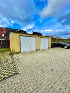a parking lot with two garage doors and a car at Ahaus: Stadtoase mit Terrasse & privater Garage in Ahaus