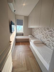 ein Wohnzimmer mit weißen Sofas und einem Fenster in der Unterkunft Ottoboni 2B Luxury Penthouse in Mailand