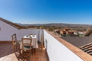 a table and chairs on a balcony with a view at Coqueta casa rural para 8 personas in Nigüelas