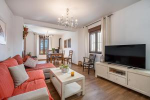 a living room with a couch and a flat screen tv at Coqueta casa rural para 8 personas in Nigüelas