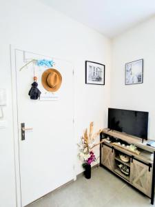 um quarto branco com uma porta e uma televisão em Studio coin nuit, Entre plage et centre em Marselha