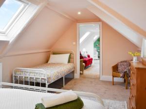 a attic bedroom with a bed and a mirror at Cartwheel Cottage in Hayton