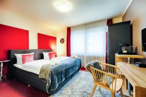 1 dormitorio con cama y pared roja en Hotel Fürst Garden, en Dortmund