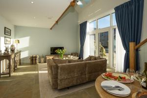 salon z kanapą i stołem w obiekcie Oystercatcher - Converted luxury steading w mieście Perth