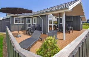 a wooden deck with chairs and an umbrella at Holiday Home Flovt Havevej Ix in Flovt