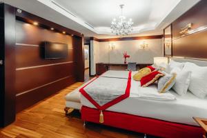 a bedroom with a large bed and a television at Dedeman Oskemen Tavros Hotel in Ustʼ-Kamenogorsk