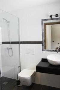 La salle de bains est pourvue de toilettes, d'un lavabo et d'un miroir. dans l'établissement Apartamento Centrico en Albir, à Albir