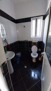 a bathroom with a white toilet and a sink at Holiday Apartment in Draç +11 photos