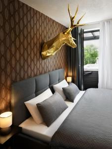 sypialnia z łóżkiem z głową jelenia na ścianie w obiekcie Sky-House Jasná Apartments w mieście Pavčina Lehota