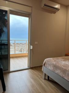 een slaapkamer met een bed en uitzicht op de oceaan bij SKetch Apartments in Durrës