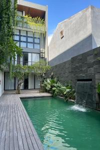 a swimming pool in front of a building at Casacotta in Seminyak