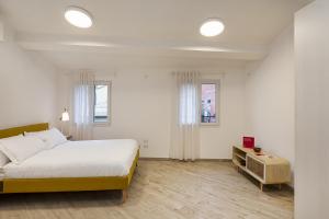 um quarto branco com uma cama e uma mesa em The Harbor Houses by Wonderful Italy em Gênova