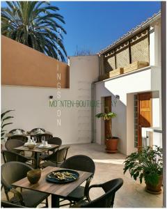 a patio with tables and chairs in front of a building at MOONTEN Boutique Stay in Sóller