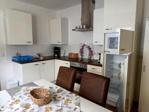 a kitchen with white cabinets and a table with chairs at Ferienhaus Ulbricht beim Senftenberger See in Hosena