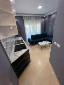 a living room with a blue couch and a table at Residence Lux Apartments at VALAMAR Hamallaj Gjiri Lalzit in Durrës